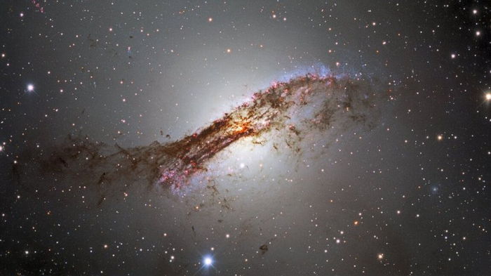 Ученые получили новый потрясающий снимок огромной галактики, окруженной нитями пыли